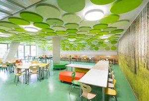 Bild einer leeren Cafeteria mit bunter Einrichtung und grünen Punkten an der Decke