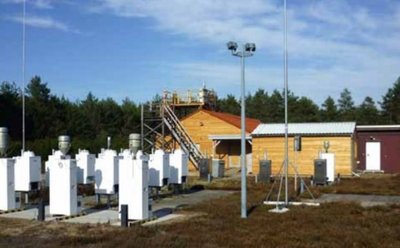 Viele weiße Luft-Messstationen des Umweltbundesamt mit Häusern im Hintergrund