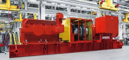 Große rotfarbene Maschine mit gelbfarbenen Elementen im Inneren einer Fabrik