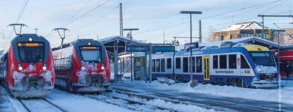 Zwei rote Züge der Deutschen Bahn und ein blau-weißer Zug der Bayrischen Regionalbahn